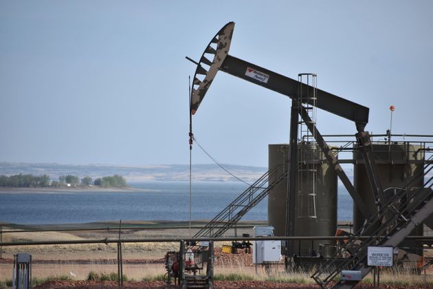 A pump jack extracts oil from beneath the ground on the Fort Berthold Indian Reservation, with Lake Sakakawea...