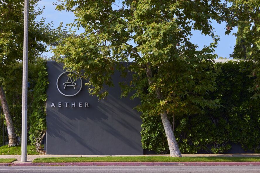 Exterior of headquarter with the name AETHER and logo seen