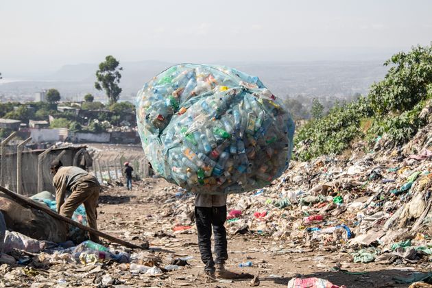 A man in Kenya carries a load of plastic