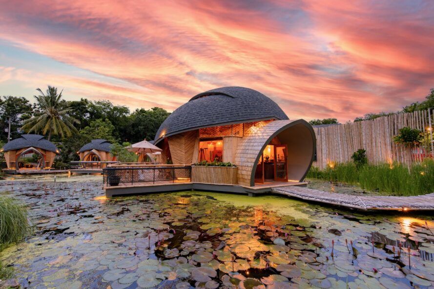 The turtle shell-shaped structure lit inside with light as the evening sky paints the background