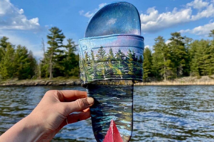 A painted flip-flop blending into a river area.